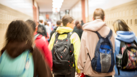 Rearview of students walking in a school hallway